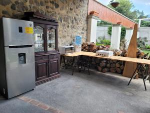 a kitchen with a counter and a refrigerator and a table at La Capitanía de San Pedro in Antigua Guatemala