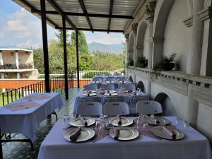 a row of tables with plates and wine glasses at La Capitanía de San Pedro in Antigua Guatemala