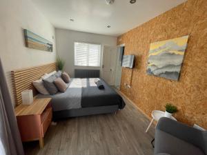 ein Schlafzimmer mit einem Bett, einem Tisch und einem Sofa in der Unterkunft Thistledene in Braunton