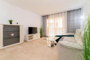 sala de estar con sofá y TV en La Recoleta Mediterranea, en Torrevieja