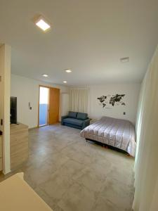 um quarto com uma cama e um sofá azul em Luxury Apartments em Mendoza