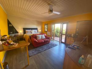 a living room with a bed and a red couch at Strip Center Suites by Casona Lo Aguirre in El Monte +289 photos