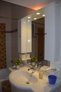a bathroom with a sink and a large mirror at Family and Relaxing House in a Village in Rodotópion