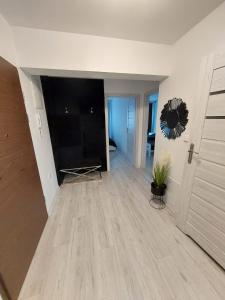 ein Wohnzimmer mit einem großen TV und einer Tür in der Unterkunft Apartament Kruklanki in Kruklanki