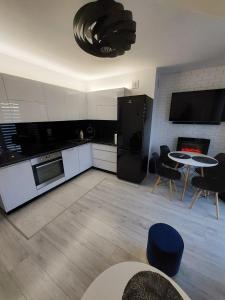a kitchen with a table and chairs and a fireplace at Apartament Kruklanki in Kruklanki