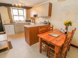 a kitchen with a wooden table with chairs and a table at Watershed Cottage in Settle