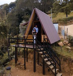 a man and a woman standing in a tree house at Glamping Jaulares Mountain in Rivas