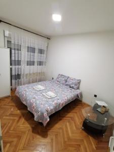ein kleines Schlafzimmer mit einem Bett und einem Tisch in der Unterkunft Apartman Caroline in Čačak