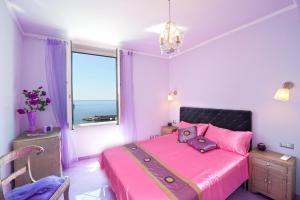 a bedroom with a pink bed with a window at Afrodite in Amalfi