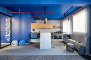 Swan Generation Porto Alegre في بورتو أليغري: مطبخ بجدران زرقاء وسقف ازرق