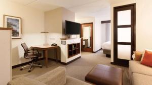 a hotel room with a desk and a room with a bed at Sonesta Select Atlanta Duluth in Duluth