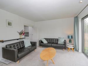 a living room with two black leather couches and a table at Ninea in Wallingford