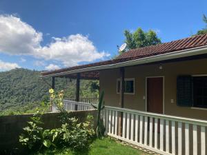 une maison avec une clôture blanche à côté d'une cour dans l'établissement Casa Vista do Vale, à Visconde de Mauá