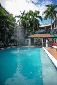 a swimming pool with a fountain in the middle of a building at Glorianna Hotel in Montego Bay