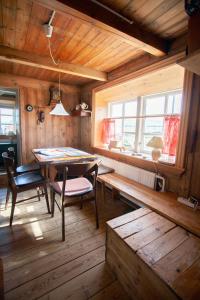 een eetkamer met een tafel en stoelen en een raam bij The Real Faroese Experience in Skálavík