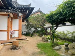 慶州的住宿－Adam Guesthouse，一座有树的房子和一座建筑的庭院