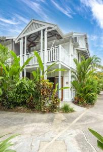 uma grande casa branca com plantas em frente em Pandanus Place - with Bicycles em Port Douglas