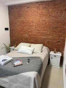 a bedroom with a bed with a brick wall at Pucara Apart - Habitaciones con baño privado in Corrientes