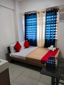 een slaapkamer met een bed met rode en blauwe gordijnen bij Urban Deca Tower EIMYS PLACE 3 in Manilla