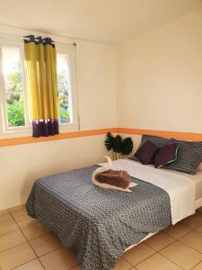 a bedroom with a bed and two windows at Maison de 3 chambres avec jardin clos et wifi a Sainte Anne a 1 km de la plage in Sainte-Anne