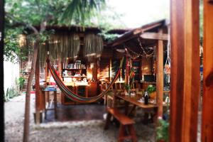 a hammock in front of a restaurant with a table at Casa Kresala, Surf House in Zorritos