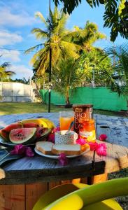 una mesa de picnic con un plato de comida y fruta en Maison de 3 chambres avec jardin clos et wifi a Sainte Anne a 1 km de la plage, en Sainte-Anne