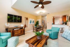 a living room with blue chairs and a tv at Kapalua Bay Vill 23G1 Ocean front 1 BD 1BA villa in Kahana