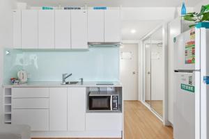 a kitchen with white cabinets and white appliances at Bayview Tower in Yeppoon