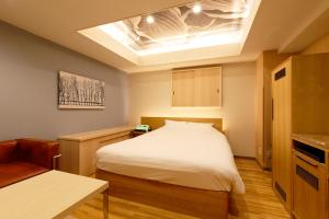 a small bedroom with a bed and a skylight at Think・Hotel・Think in Ebina