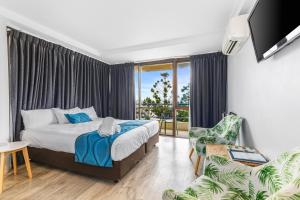 a bedroom with a bed and a balcony at Bayview Tower in Yeppoon