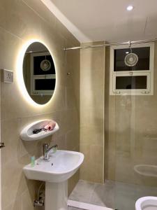 a bathroom with a sink and a mirror and a shower at Al Rawdha Hotel Apartments in Sharjah +32 photos