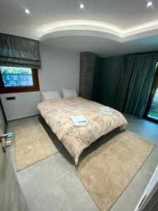 a bedroom with a bed with two rugs in it at Evelina’s house in Neochorópoulon