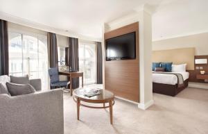 a hotel room with a bed and a living room at Thistle London Piccadilly in London