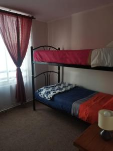 a bedroom with two bunk beds and a window at Arriendo diario a pasos playa la herradura in Coquimbo