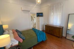 a bedroom with a green bed and a dresser at Urban Getaway Ipswich Central in Ipswich