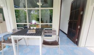 Karon House 15B في شاطئ كارون: طاولة وكراسي على شرفة مع نافذة