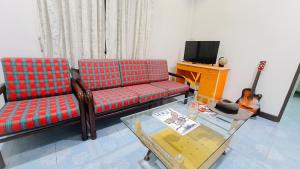 - un salon avec un canapé et une guitare dans l'établissement Karon House 15B, à Karon Beach