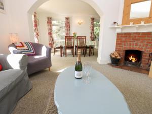 a living room with a bottle of wine on a table at Baytree Cottage in Totland