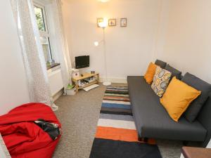 a living room with a couch and a television at Baytree Cottage in Totland
