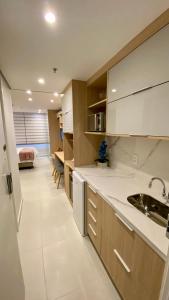 - une cuisine avec des placards blancs et un évier dans l'établissement Estudio Em Itaipava - Granja Brasil - Flat Luxo - Com Piscina Aquecida, à Itaipava