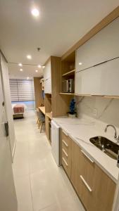 a kitchen with white cabinets and a sink at Estúdios Em Itaipava - Granja Brasil - Conforto e Lazer in Itaipava