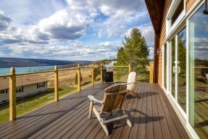a deck with two chairs and a trash can at Seneca Lake Getaway in Burdett