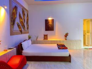 Chợ GạoにあるKhách sạn SAKÊ Tiền Giangのベッドルーム1室(ベッド1台、赤い椅子付)