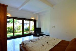 a bedroom with a bed and a television in it at Villa Family in Canggu