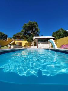 a large swimming pool with a slide in a resort at Casa de praia na Reserva do Peró em Cabo Frio - familiar com piscina in Cabo Frio