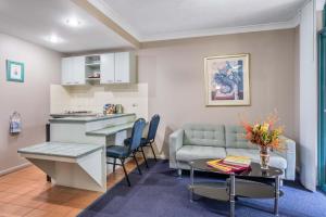 a kitchen and a living room with a couch and a table at Albion Manor in Brisbane