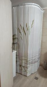 a shower curtain with a plant on it in a bathroom at Catherine's Studio in Monódhrion
