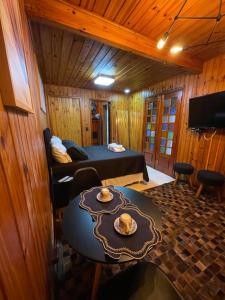 um quarto com uma cama e uma mesa em uma sala em Chalé Geburt em Monte Verde