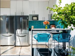 a kitchen with stainless steel appliances and blue tiles at Casa Pánuco in Mexico City