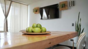 miskę zielonych jabłek na drewnianym stole w obiekcie Espacio Norte Familiar - Cavancha w mieście Iquique